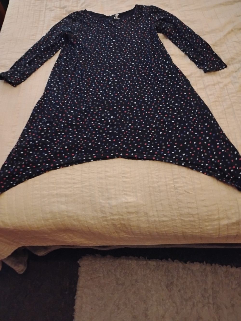 Long sleeve tunic with a shark bite hemline. Black With Multicolored Polka Dots.